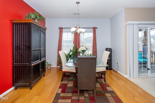 dining room featuring hardwood / wood-style floors and a chandelier