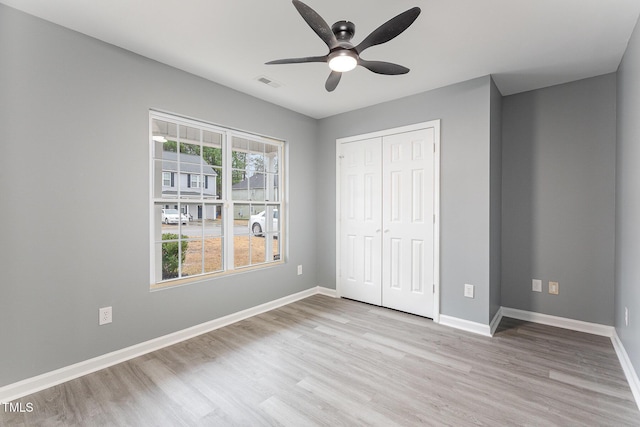 unfurnished bedroom featuring ceiling fan, light wood-type flooring, and a closet