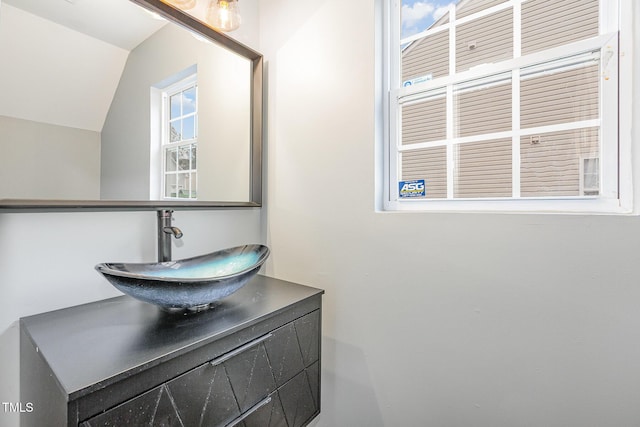 bathroom featuring vanity and lofted ceiling