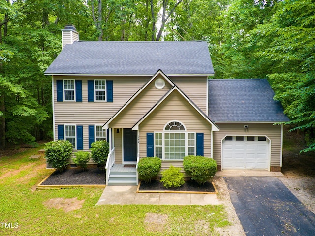 view of front of home featuring a front yard, a garage, and covered porch