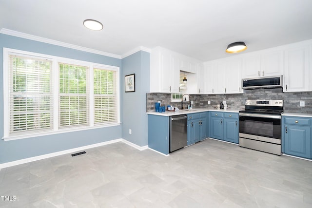 kitchen with backsplash, white cabinetry, blue cabinetry, and appliances with stainless steel finishes