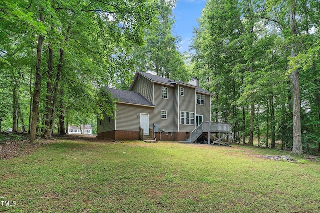 rear view of property featuring a lawn and a deck