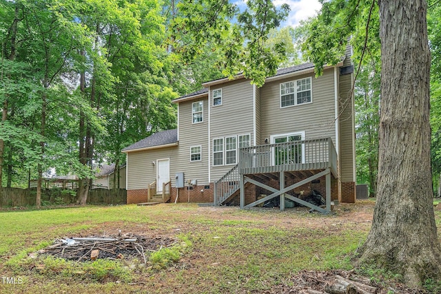 rear view of house with a lawn and a deck