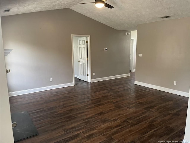 empty room with a textured ceiling, dark hardwood / wood-style floors, vaulted ceiling, and ceiling fan