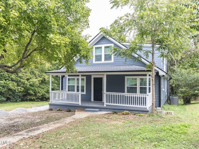 view of front of house featuring covered porch, a front lawn, and cooling unit