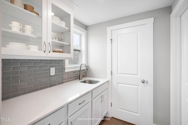 kitchen with tasteful backsplash, sink, and white cabinets