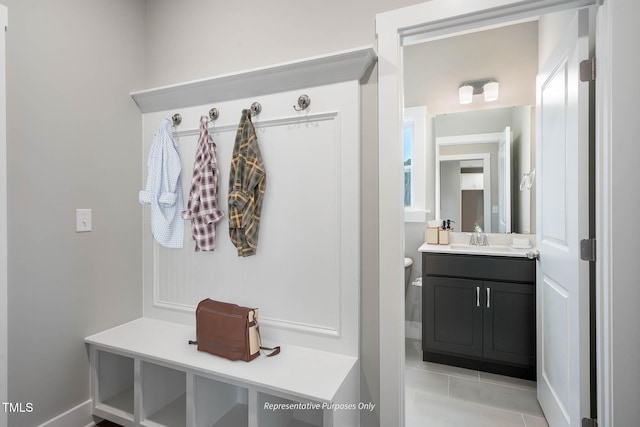 mudroom with sink and light tile patterned flooring