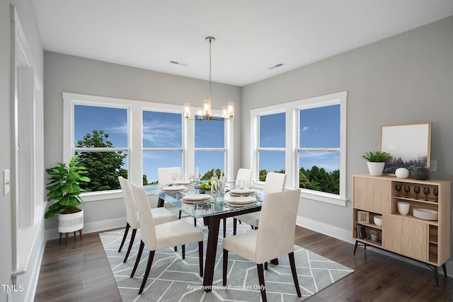 dining space featuring dark wood-type flooring and an inviting chandelier