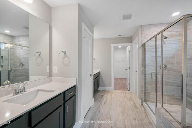 bathroom featuring vanity and a shower with shower door