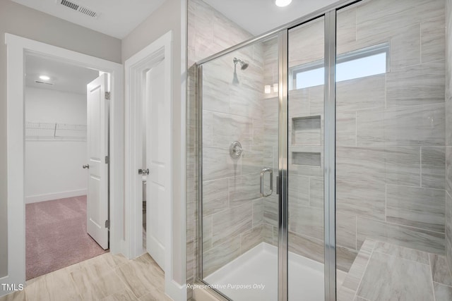 bathroom featuring a shower with door