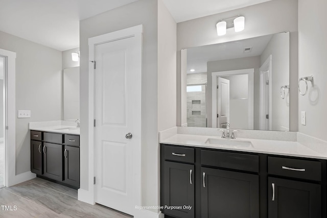 bathroom featuring hardwood / wood-style floors, vanity, and an enclosed shower