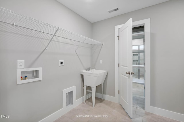 clothes washing area with hookup for an electric dryer, light tile patterned floors, and hookup for a washing machine