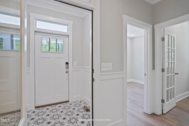 entrance foyer with light hardwood / wood-style floors and crown molding