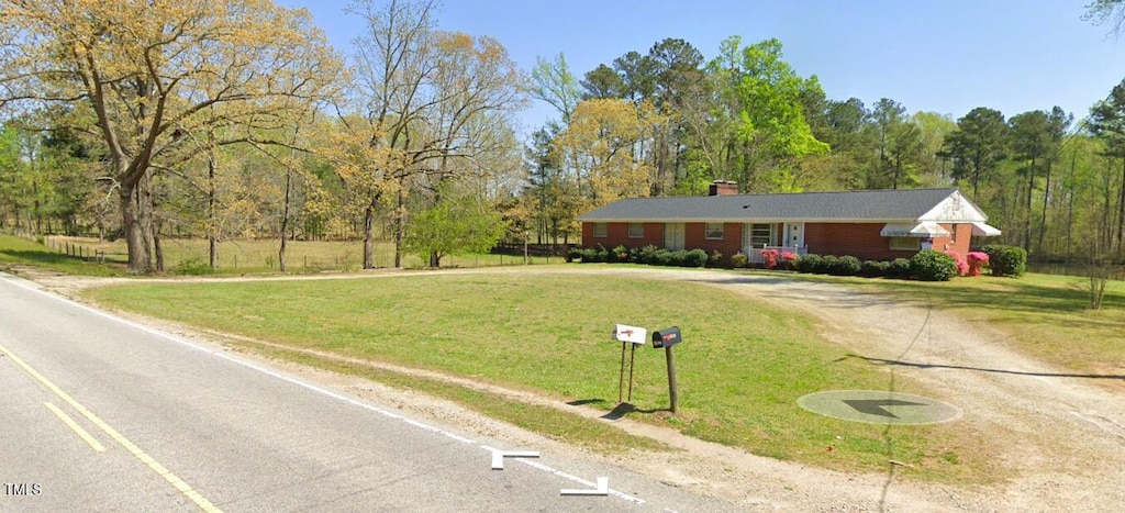 ranch-style home featuring a front lawn