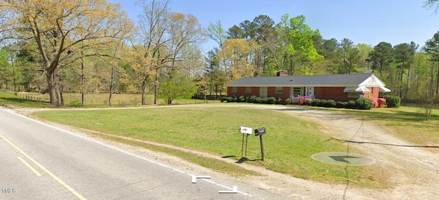 ranch-style home featuring a front lawn