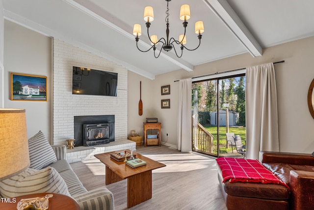 living room featuring a brick fireplace, lofted ceiling with beams, light wood-type flooring, and an inviting chandelier