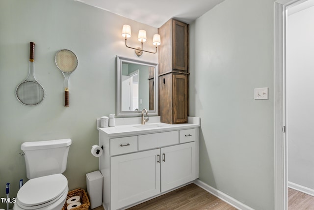 bathroom with hardwood / wood-style floors, vanity, and toilet