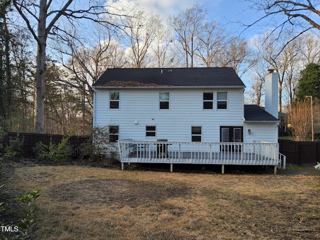 rear view of house featuring a lawn and a deck