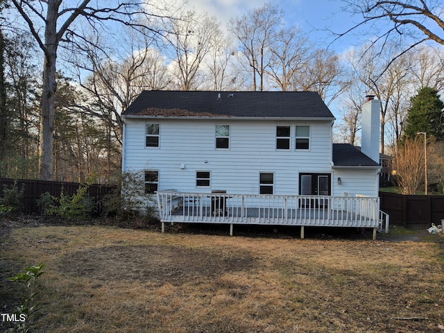 back of house featuring a wooden deck and a lawn