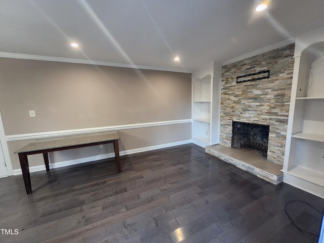 interior space featuring built in shelves, a stone fireplace, and ornamental molding