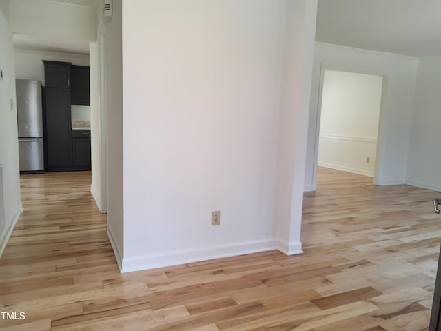 hall with ornamental molding and light wood-type flooring