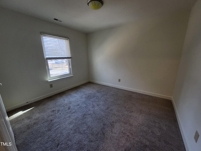 unfurnished room with dark carpet