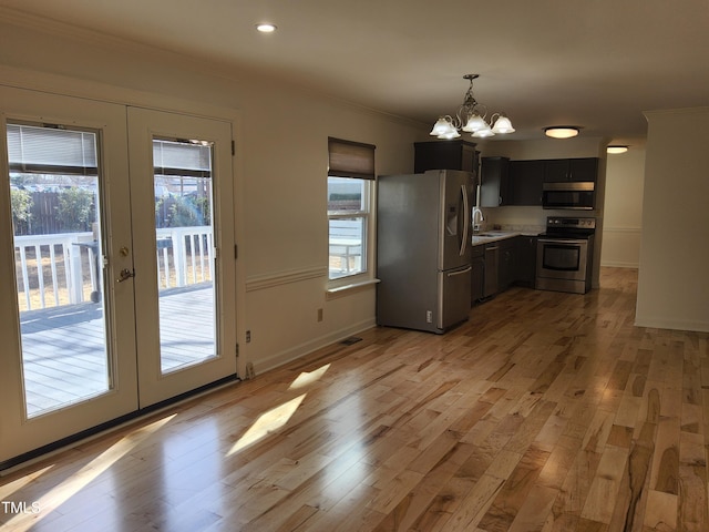 kitchen with stainless steel appliances, a notable chandelier, ornamental molding, french doors, and light wood-type flooring