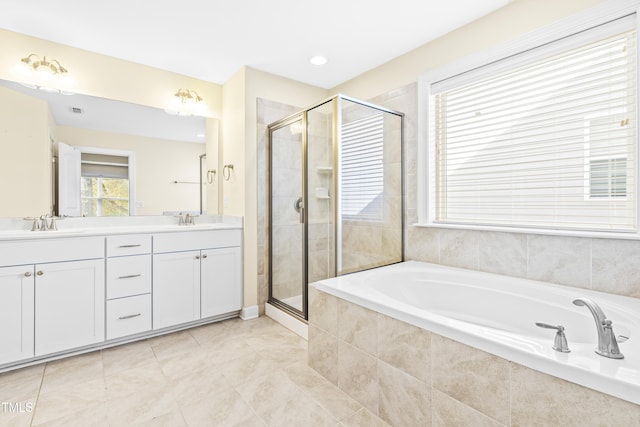 bathroom with tile patterned floors, vanity, and shower with separate bathtub