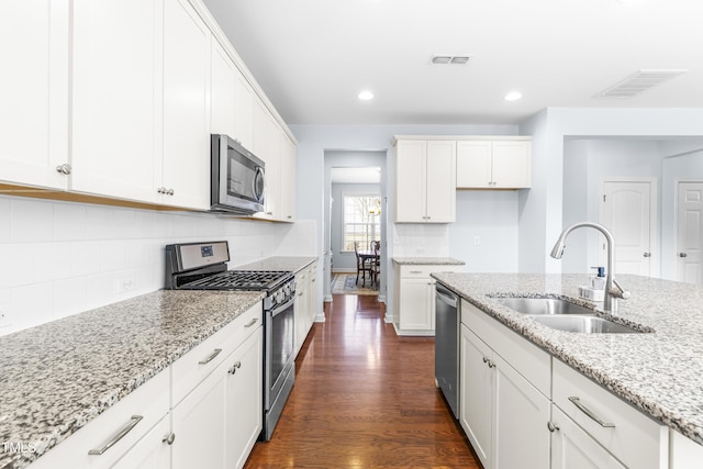 kitchen with light stone counters, sink, white cabinetry, and stainless steel appliances