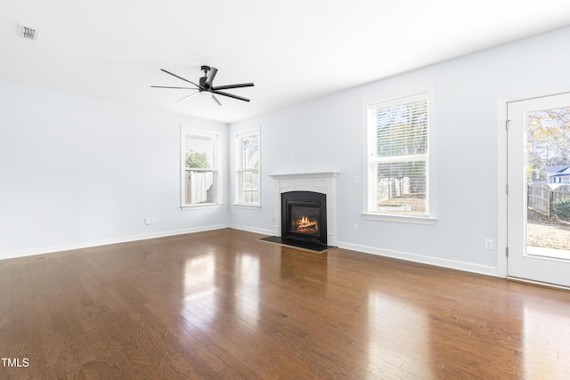 unfurnished living room with dark hardwood / wood-style floors, ceiling fan, and a wealth of natural light