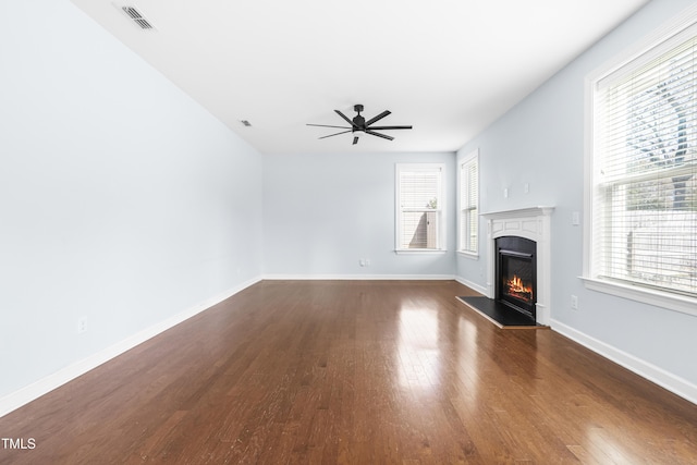 unfurnished living room with ceiling fan and dark wood-type flooring