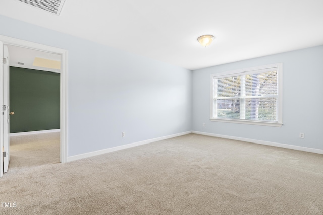 spare room featuring light carpet