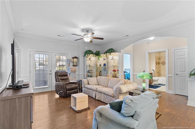 living room featuring ceiling fan, wood-type flooring, ornamental molding, and french doors