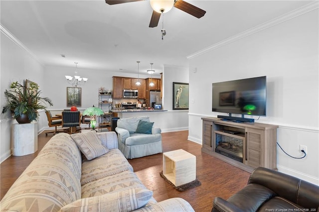 living room featuring ceiling fan with notable chandelier, dark hardwood / wood-style flooring, and ornamental molding