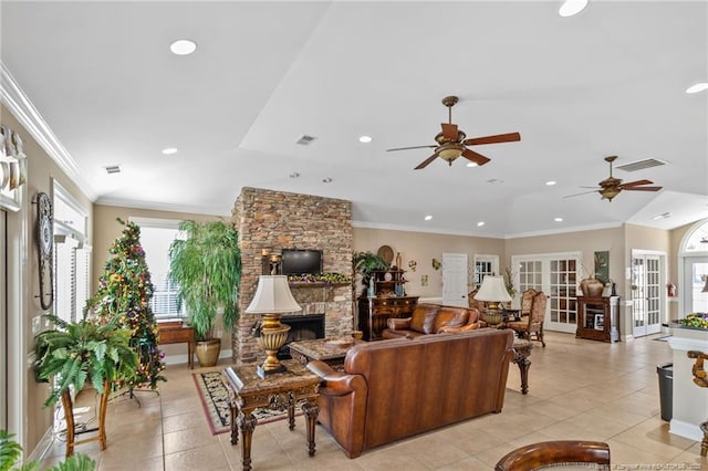 living room featuring french doors, ornamental molding, ceiling fan, a fireplace, and light tile patterned flooring