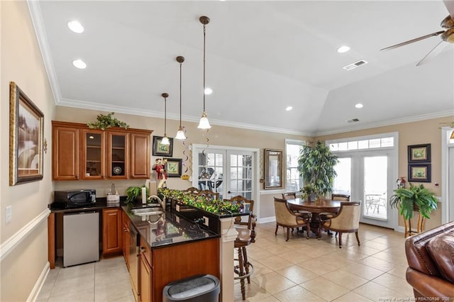 kitchen featuring a kitchen breakfast bar, a wealth of natural light, pendant lighting, and vaulted ceiling