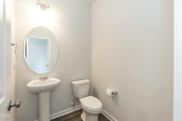 bathroom with hardwood / wood-style flooring, toilet, and sink