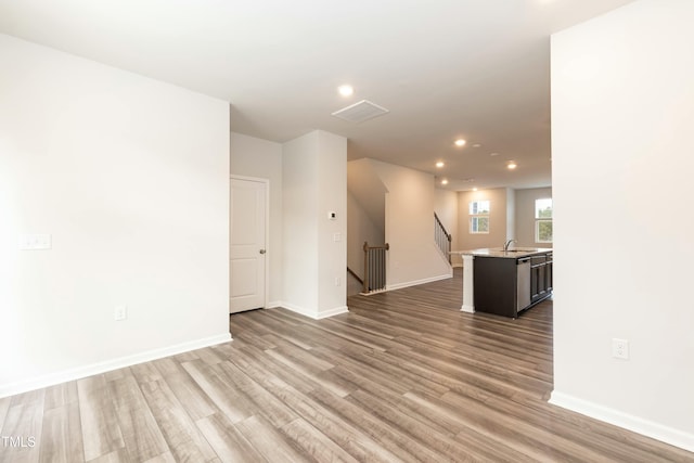 spare room featuring sink and light hardwood / wood-style flooring