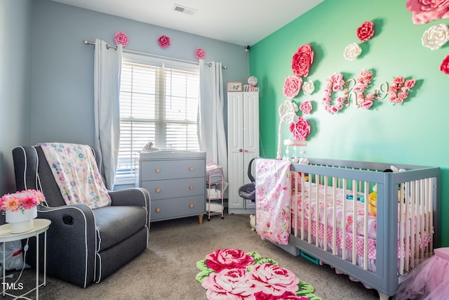 bedroom featuring light colored carpet and a nursery area