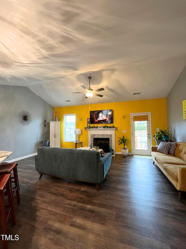 living room featuring vaulted ceiling, dark hardwood / wood-style floors, and ceiling fan