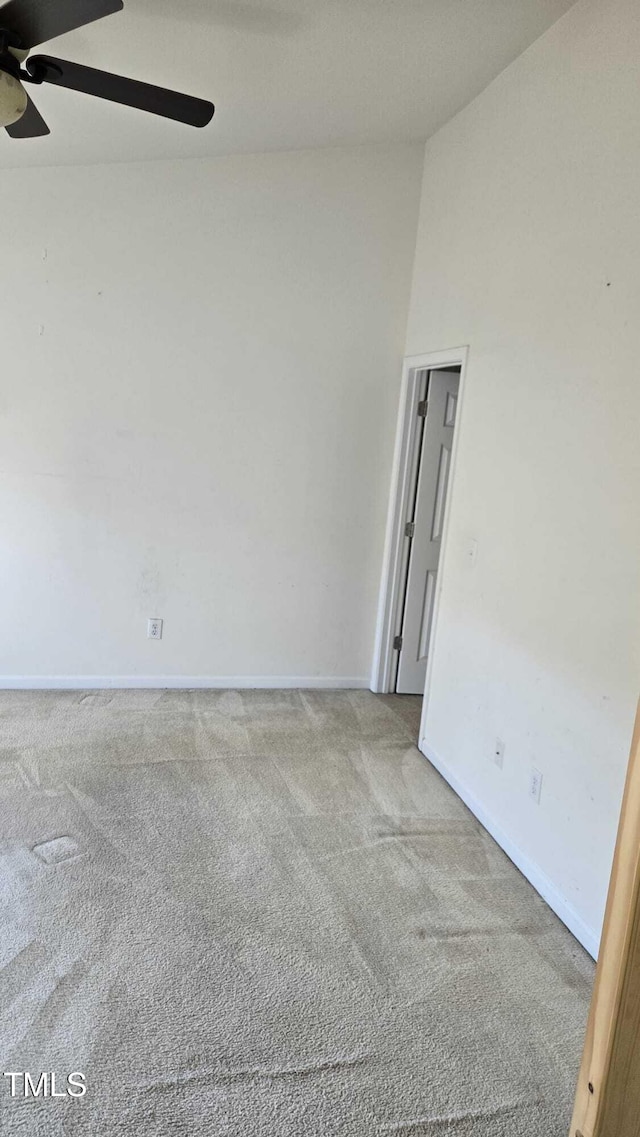 spare room featuring light carpet and ceiling fan