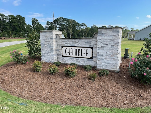 community / neighborhood sign featuring a lawn