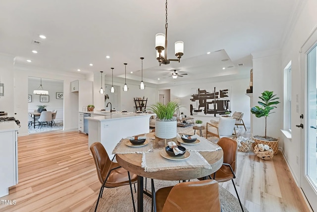 dining room featuring ornamental molding, sink, and light hardwood / wood-style flooring