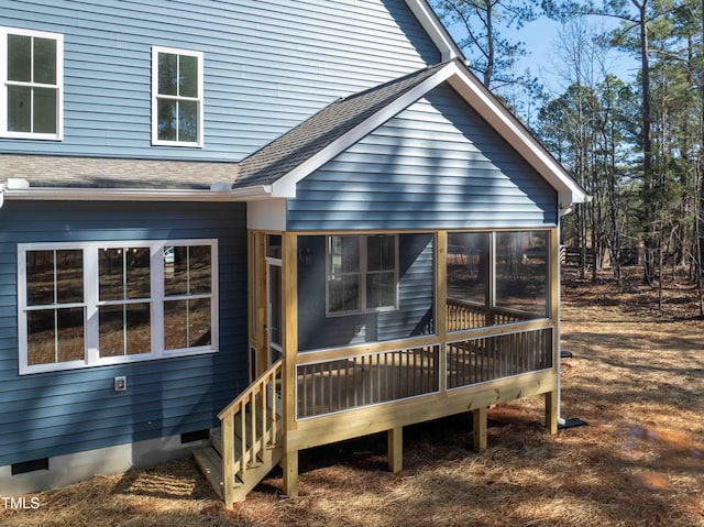 rear view of house featuring roof with shingles, a sunroom, and crawl space