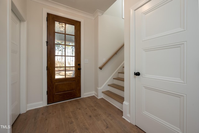 interior space featuring baseboards, wood finished floors, and stairs