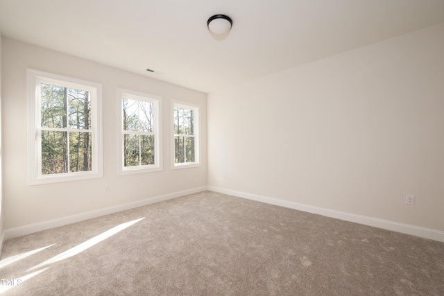 empty room featuring baseboards, carpet floors, and visible vents