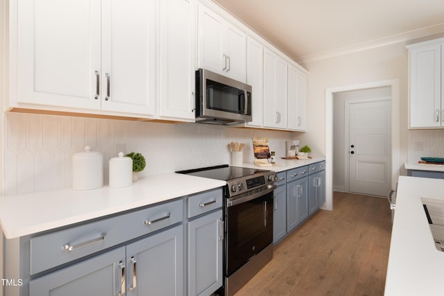 kitchen featuring light wood-style flooring, gray cabinets, white cabinetry, appliances with stainless steel finishes, and light countertops