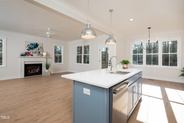 kitchen with light wood finished floors, crown molding, dishwashing machine, a fireplace, and a sink