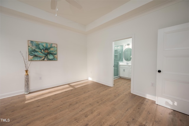 unfurnished room with a ceiling fan, baseboards, and wood finished floors