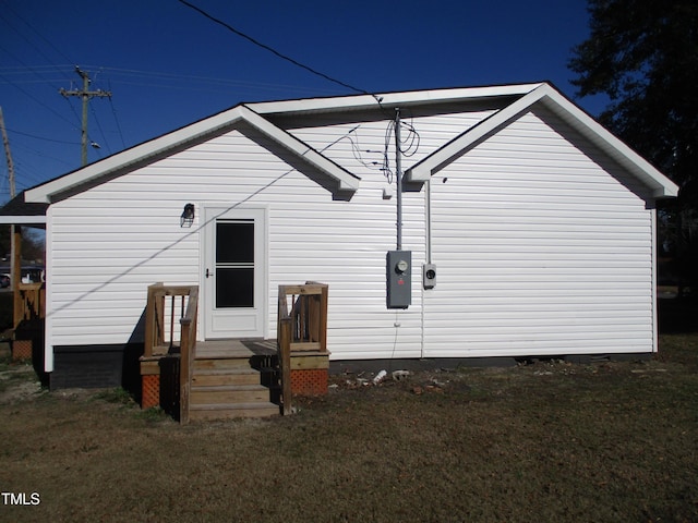 rear view of property featuring a lawn